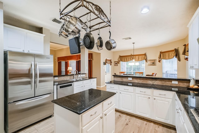 13330 Via Torre De Pisa Ln, Cypress, TX 77429 - kitchen featuring stainless steel appliances, a peninsula, white cabinets, hanging light fixtures, and recessed lighting