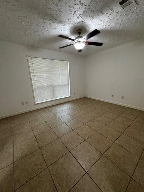 16310 Meadowbrook Farm Rd, Houston, TX 77082 - empty room with a textured ceiling, a ceiling fan, and tile patterned floors