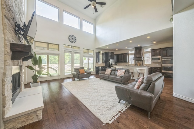 47 Chestnut Meadow Dr, Conroe, TX 77384 - living room featuring a fireplace, ceiling fan, dark wood-type flooring, and a high ceiling