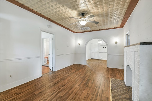 702 Caplin St, Houston, TX 77022 - unfurnished living room with an ornate ceiling, arched walkways, ceiling fan, wood finished floors, and crown molding