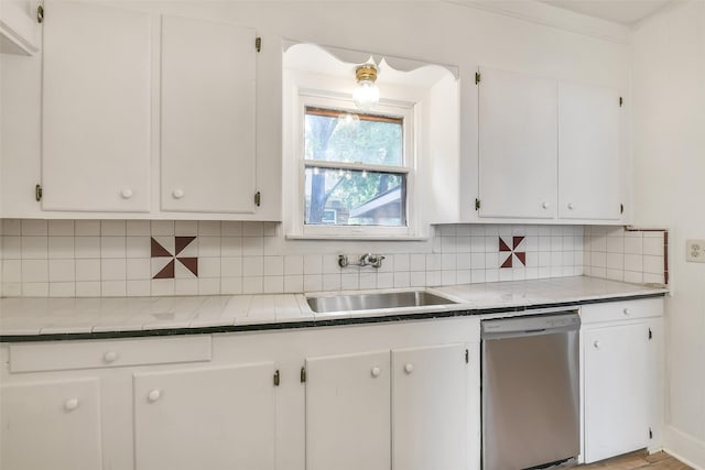 702 Caplin St, Houston, TX 77022 - kitchen with stainless steel dishwasher, white cabinets, and backsplash