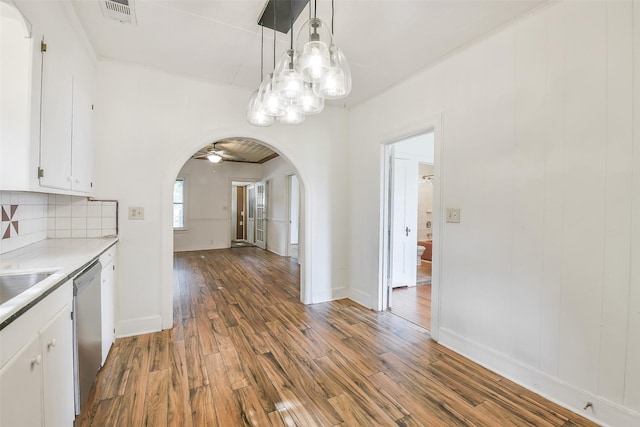 702 Caplin St, Houston, TX 77022 - kitchen with arched walkways, wood finished floors, white cabinetry, and light countertops