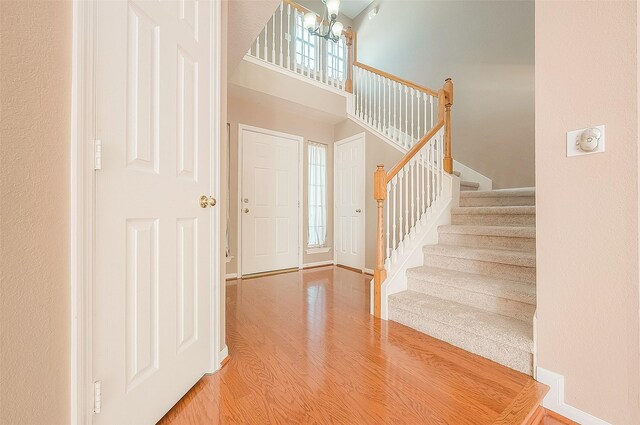 7210 Welshwood Ln, Sugar Land, TX 77479 - entrance foyer with stairway, a chandelier, wood finished floors, and a towering ceiling