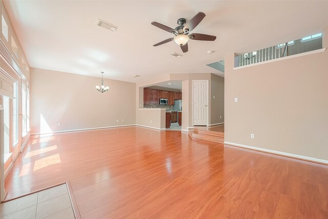 7210 Welshwood Ln, Sugar Land, TX 77479 - unfurnished living room with a ceiling fan, a chandelier, and light wood-style flooring
