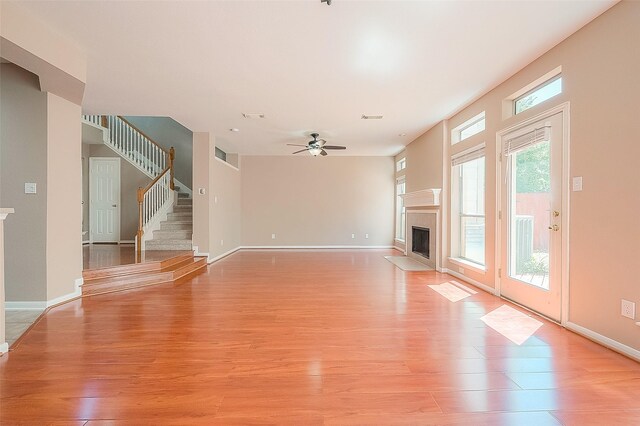 7210 Welshwood Ln, Sugar Land, TX 77479 - unfurnished living room featuring light wood-style floors, ceiling fan, and a high end fireplace