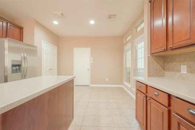 7210 Welshwood Ln, Sugar Land, TX 77479 - kitchen featuring stainless steel fridge with ice dispenser, light countertops, backsplash, brown cabinets, and recessed lighting
