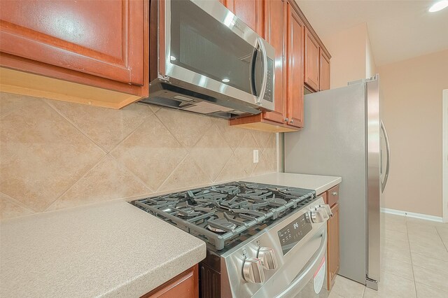 7210 Welshwood Ln, Sugar Land, TX 77479 - kitchen featuring stainless steel appliances, brown cabinetry, tasteful backsplash, and light countertops