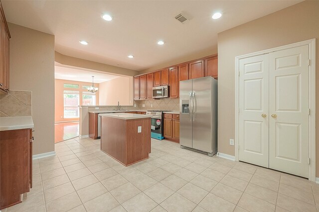 7210 Welshwood Ln, Sugar Land, TX 77479 - kitchen featuring stainless steel appliances, a chandelier, tasteful backsplash, light countertops, and light tile patterned flooring
