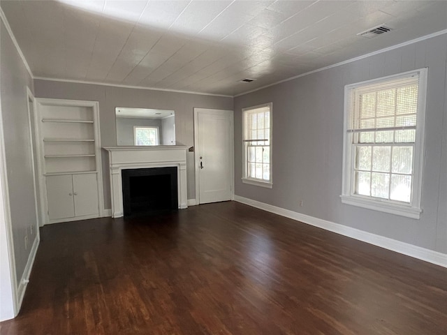 4905 Jackson St, Houston, TX 77004 - unfurnished living room featuring crown molding, dark wood-type flooring, plenty of natural light, built in features, and a fireplace