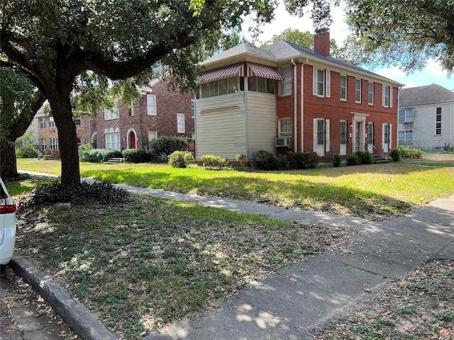 4905 Jackson St, Houston, TX 77004 - view of front of house with brick siding, a chimney, a front yard, and cooling unit