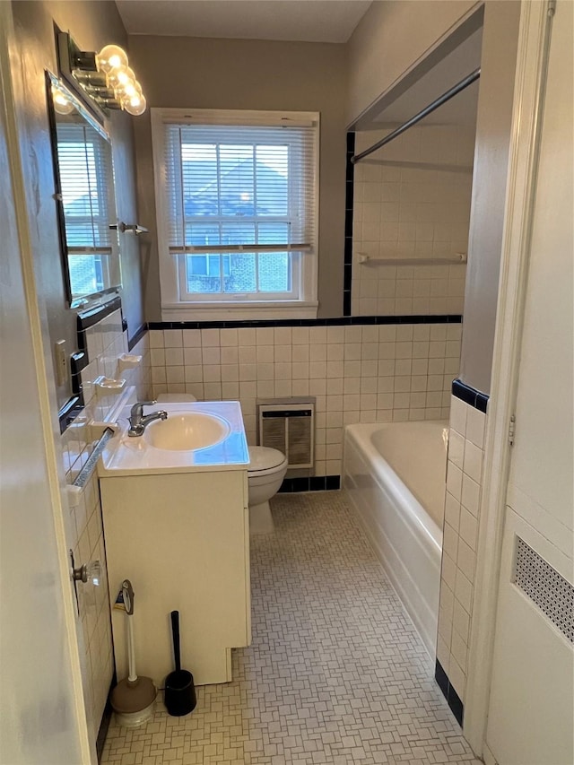 4905 Jackson St, Houston, TX 77004 - full bathroom with heating unit, healthy amount of natural light, vanity, tile walls, and shower / bath combination