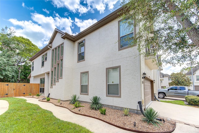 1415 Baldwin Square Ln, Houston, TX 77077 - view of home's exterior featuring a garage, stucco siding, and concrete driveway