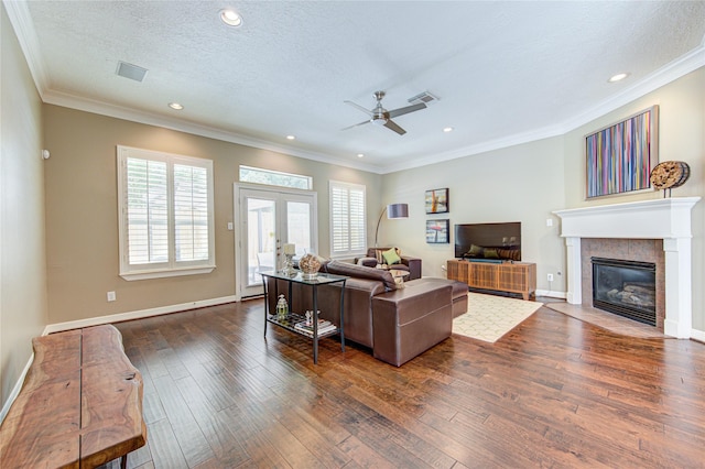 1415 Baldwin Square Ln, Houston, TX 77077 - living room featuring dark wood finished floors, plenty of natural light, ceiling fan, a tiled fireplace, and crown molding