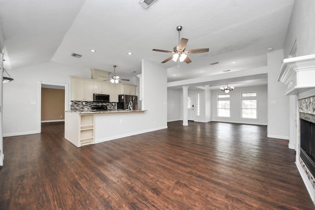 204 Audubon Woods Ct, Richwood, TX 77531 - unfurnished living room featuring a fireplace, ceiling fan, a chandelier, dark wood finished floors, and vaulted ceiling