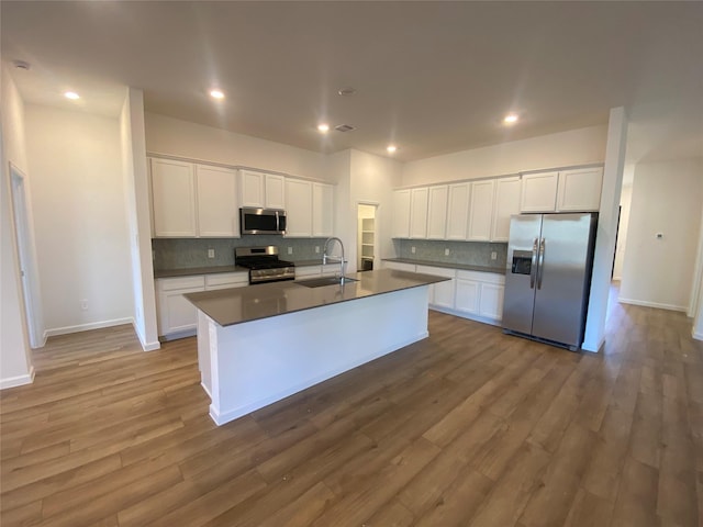 17910 Rillette Rd, Conroe, TX 77302 - kitchen featuring appliances with stainless steel finishes, dark countertops, tasteful backsplash, white cabinets, and recessed lighting