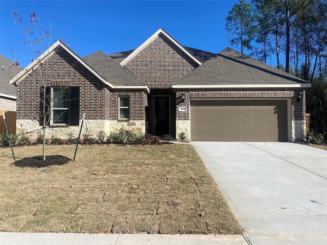 17910 Rillette Rd, Conroe, TX 77302 - view of front of home featuring an attached garage, stone siding, a front lawn, roof with shingles, and concrete driveway