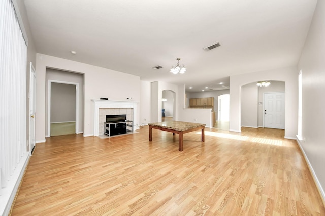 24219 Camillia Ridge Way, Katy, TX 77493 - unfurnished living room featuring arched walkways, light wood finished floors, and a chandelier
