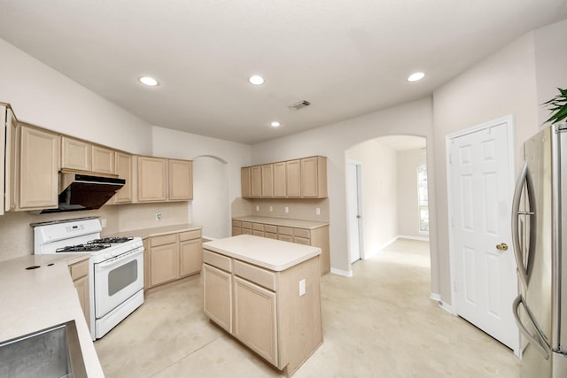 24219 Camillia Ridge Way, Katy, TX 77493 - kitchen with white gas range, light brown cabinets, freestanding refrigerator, arched walkways, and under cabinet range hood