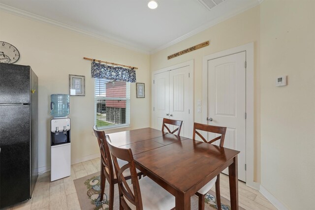 2577 Holiday Dr, Crystal Beach, TX 77650 - dining area with ornamental molding and light wood-style flooring
