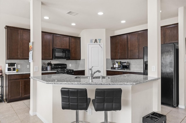 9127 Sasson Blvd, Houston, TX 77044 - kitchen with black appliances, light tile patterned flooring, an island with sink, backsplash, and recessed lighting