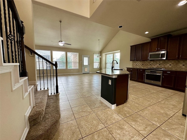 22411 Limestone Crest Ln, Katy, TX 77449 - kitchen with appliances with stainless steel finishes, decorative backsplash, light tile patterned flooring, open floor plan, and dark brown cabinets