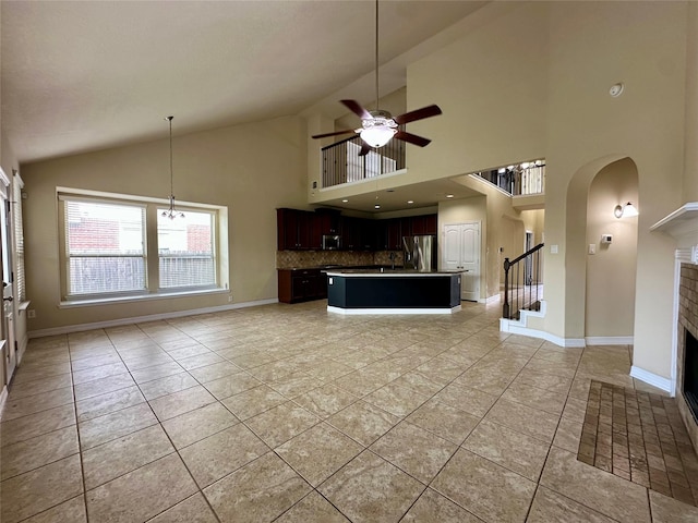 22411 Limestone Crest Ln, Katy, TX 77449 - unfurnished living room with ceiling fan, a fireplace, light tile patterned floors, arched walkways, and high vaulted ceiling