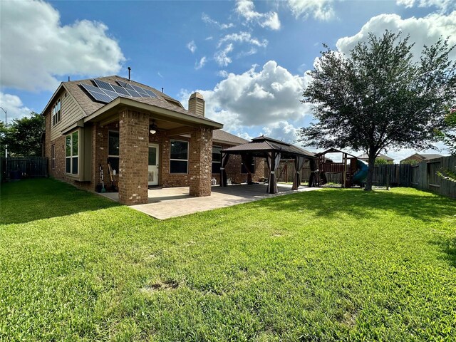 22411 Limestone Crest Ln, Katy, TX 77449 - rear view of house with a patio, solar panels, a gazebo, brick siding, and a chimney