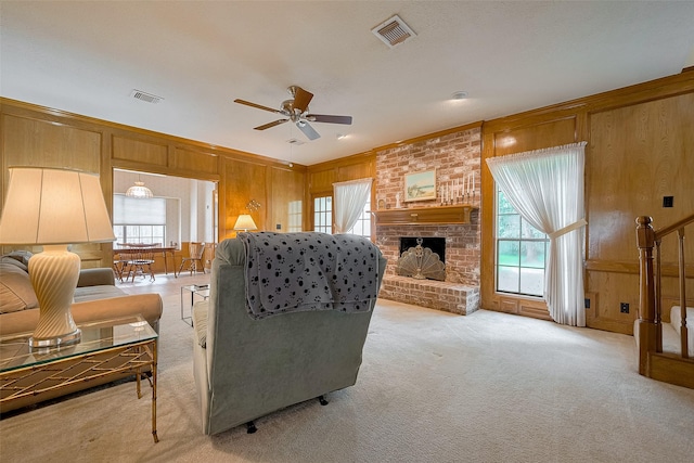 17718 Terrawren Ln, Spring, TX 77379 - living room featuring wood walls, a ceiling fan, light colored carpet, a fireplace, and ornamental molding