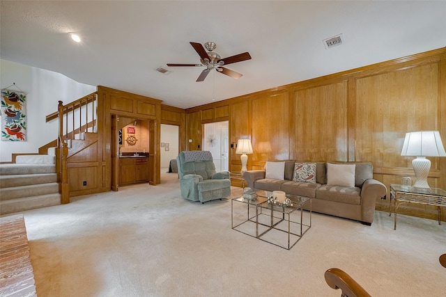 17718 Terrawren Ln, Spring, TX 77379 - living room featuring a ceiling fan, light carpet, stairs, and wood walls