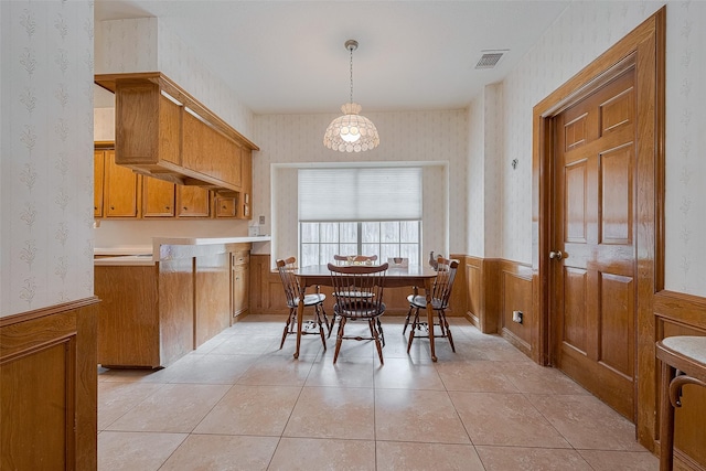 17718 Terrawren Ln, Spring, TX 77379 - dining room with wallpapered walls, a wainscoted wall, light tile patterned flooring, and a chandelier
