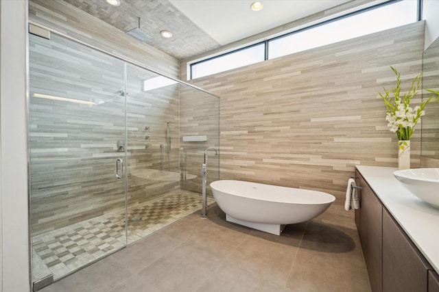 2332 Wroxton Rd, Houston, TX 77005 - bathroom with vanity, a shower stall, a freestanding tub, tile walls, and tile patterned floors