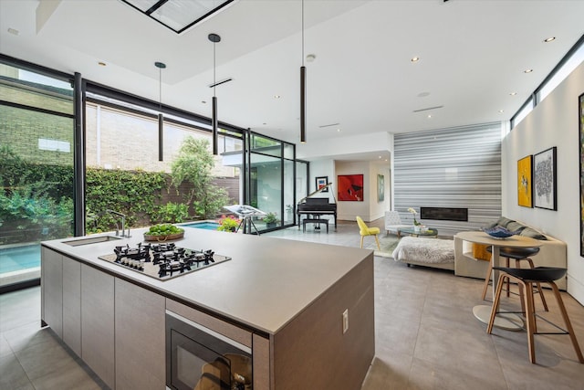 2332 Wroxton Rd, Houston, TX 77005 - kitchen featuring gas stovetop, built in microwave, a wall of windows, modern cabinets, and open floor plan