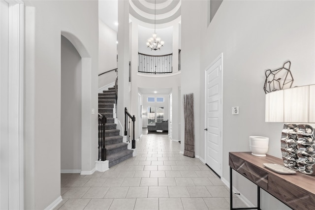 2131 Acadian Way, Brookshire, TX 77423 - foyer with stairs, a high ceiling, light tile patterned floors, a chandelier, and arched walkways