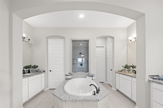 2131 Acadian Way, Brookshire, TX 77423 - full bathroom featuring two vanities, a garden tub, tile patterned flooring, a tile shower, and recessed lighting