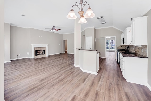 461 Cumberland Trl, Conroe, TX 77302 - kitchen featuring dark countertops, white cabinetry, a ceiling fan, a chandelier, and vaulted ceiling