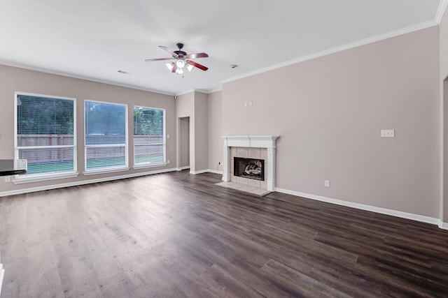 461 Cumberland Trl, Conroe, TX 77302 - unfurnished living room featuring ceiling fan, dark wood-style flooring, a tiled fireplace, and ornamental molding