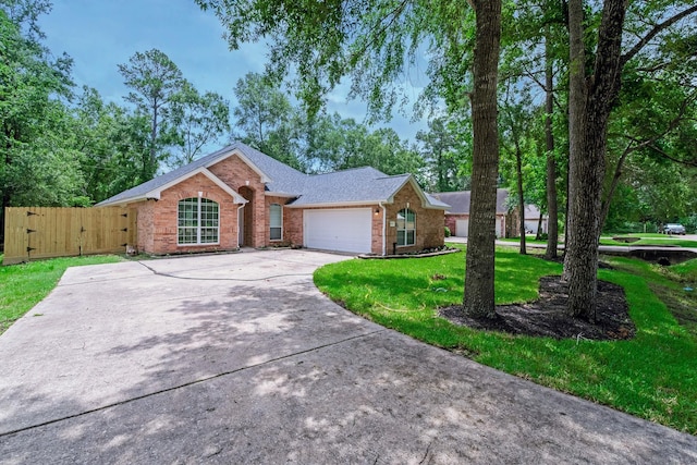 461 Cumberland Trl, Conroe, TX 77302 - view of front of property with brick siding, a garage, driveway, roof with shingles, and a gate