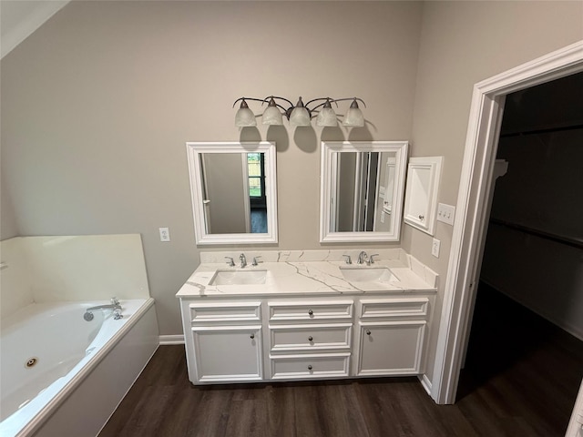 461 Cumberland Trl, Conroe, TX 77302 - bathroom featuring wood finished floors, double vanity, a jetted tub, and a spacious closet