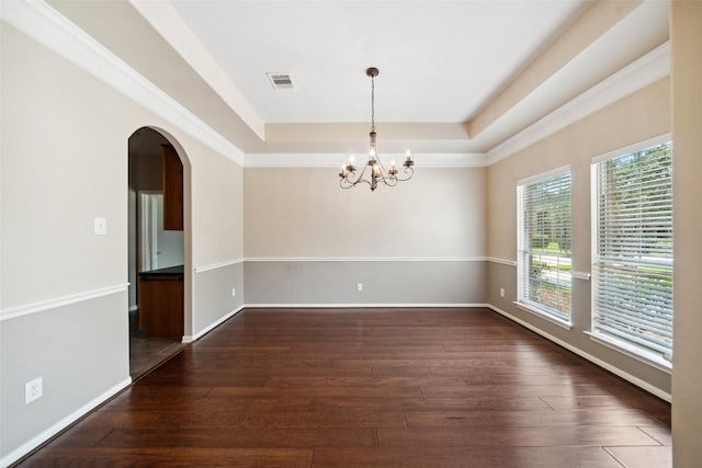 15331 Springhill Bend Ln, Cypress, TX 77429 - empty room featuring a tray ceiling, a chandelier, dark wood-style flooring, and arched walkways