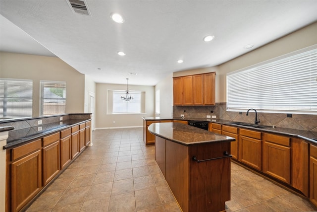 15331 Springhill Bend Ln, Cypress, TX 77429 - kitchen with a center island, a chandelier, tasteful backsplash, brown cabinetry, and black dishwasher