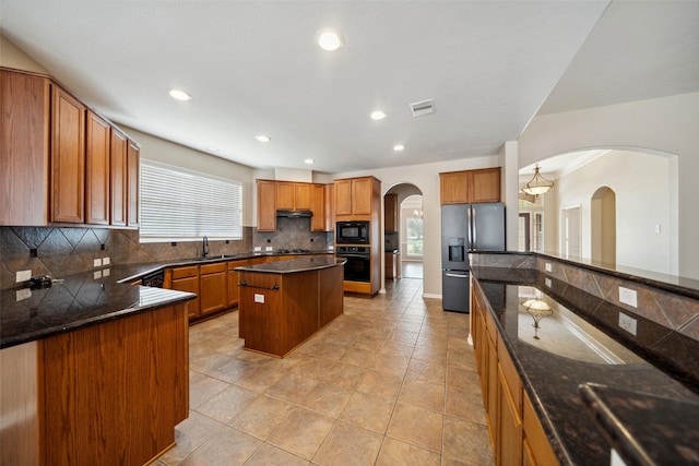15331 Springhill Bend Ln, Cypress, TX 77429 - kitchen with black appliances, tasteful backsplash, brown cabinetry, and recessed lighting