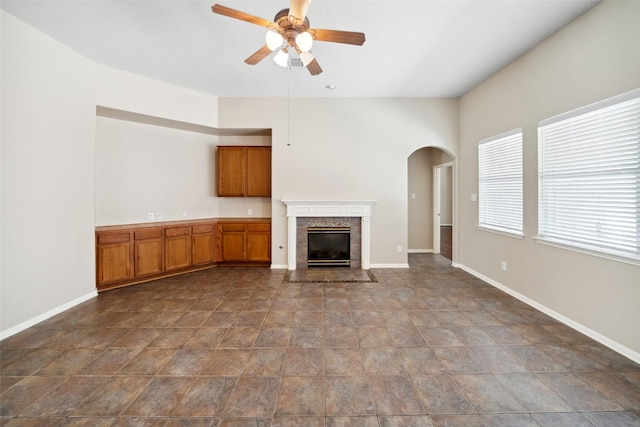 15331 Springhill Bend Ln, Cypress, TX 77429 - unfurnished living room with ceiling fan, arched walkways, and a tile fireplace