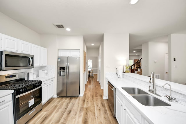 235 Cedar Elm Ln, Sugar Land, TX 77479 - kitchen featuring appliances with stainless steel finishes, light wood-style floors, white cabinets, tasteful backsplash, and recessed lighting
