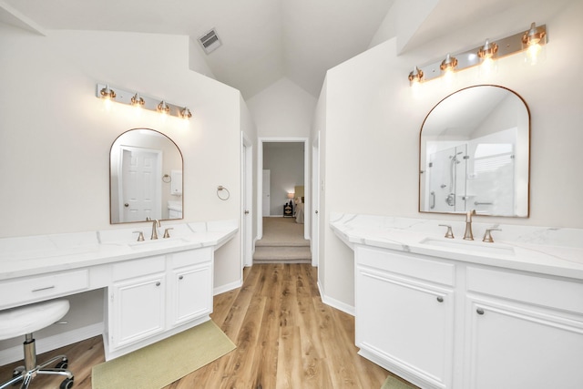 235 Cedar Elm Ln, Sugar Land, TX 77479 - full bathroom with two vanities, lofted ceiling, wood finished floors, and a shower with door