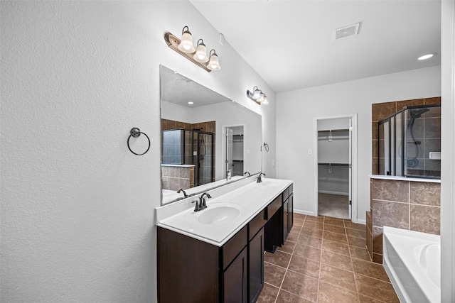 9203 Sasson Blvd, Houston, TX 77044 - bathroom featuring a walk in closet, a shower stall, double vanity, a bath, and recessed lighting