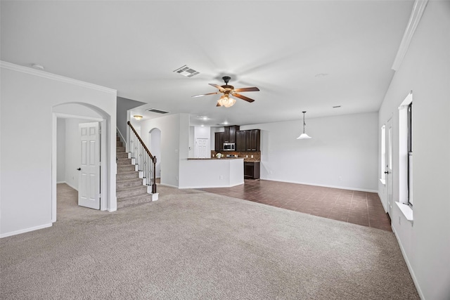 9203 Sasson Blvd, Houston, TX 77044 - unfurnished living room featuring dark colored carpet, arched walkways, ceiling fan, crown molding, and stairway