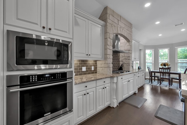31268 New Forest Park Ln, Spring, TX 77386 - kitchen featuring stainless steel appliances, wall chimney exhaust hood, backsplash, white cabinets, and recessed lighting
