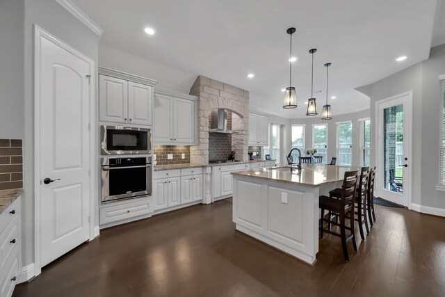31268 New Forest Park Ln, Spring, TX 77386 - kitchen featuring stainless steel appliances, tasteful backsplash, white cabinetry, recessed lighting, and a breakfast bar area