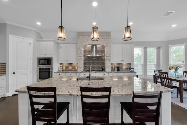 31268 New Forest Park Ln, Spring, TX 77386 - kitchen with stainless steel appliances, wall chimney range hood, tasteful backsplash, white cabinets, and recessed lighting
