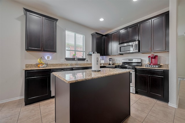 5830 Acacia Rose Ct, Richmond, TX 77407 - kitchen featuring appliances with stainless steel finishes, light stone countertops, a center island, light tile patterned floors, and recessed lighting